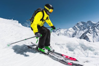 Profesyonel kayakçı kış mavi gökyüzü ve dağlar karşı buzul atlama önce hızda