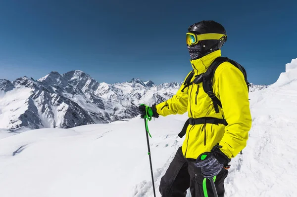 Porträtt av en professionell freerider skidåkare står på en snöig backe mot bakgrund av snöklädda berg. Begreppet vintersport — Stockfoto