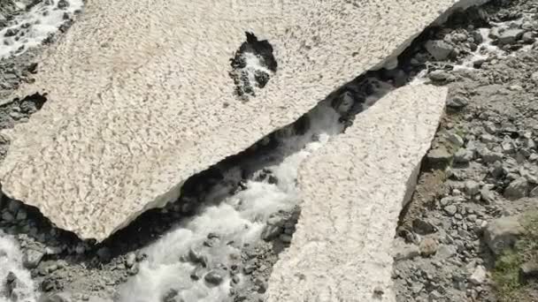 Rocky river i kamienie z pozostałościami góry śnieg w górski krajobraz przewiewne. Górskie rzeki z dużych kamieni. Widok z najwyższego lotu nad rzeką — Wideo stockowe