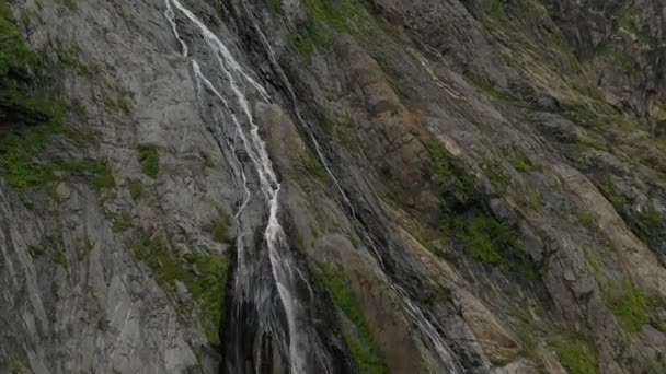 Suivi et prise de vue en haut Un jet d'air provenant d'un ruisseau qui éclaboussait une cascade sur une paroi rocheuse dans les montagnes du Caucase. Autour du jet de la cascade — Video