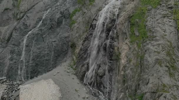 Tracciamento e tiro in alto Air sparato da un flusso di acqua spruzzi cascata su una parete rocciosa nelle montagne del Caucaso. Intorno al getto della cascata — Video Stock