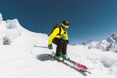 Profesyonel kayakçı kış mavi gökyüzü ve dağlar karşı buzul atlama önce hızda