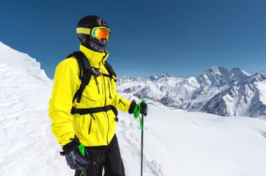 Arka planı karla kaplı Dağları'nın karlı bir yamaç üzerinde duran bir profesyonel freerider kayakçı portresi. Kış sporları kavramı