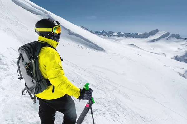 一个专业的 freerider 滑雪者的肖像站在雪地上的斜坡上的积雪山脉的背景。冬季体育的概念 — 图库照片