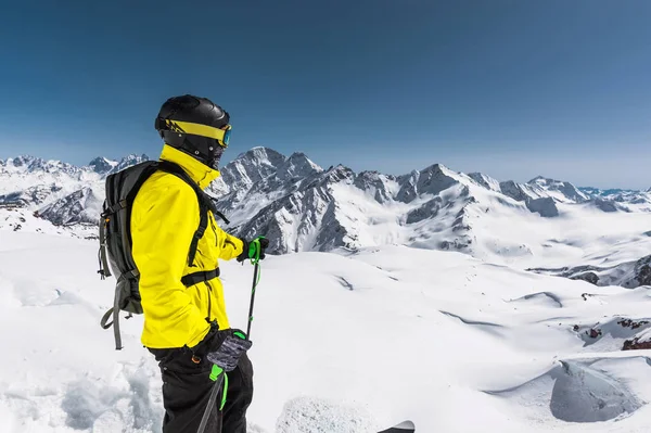 背景に雪をかぶった山々 の雪が多い斜面の上に立ってプロ freerider スキーヤーの肖像画。冬のスポーツの概念 — ストック写真
