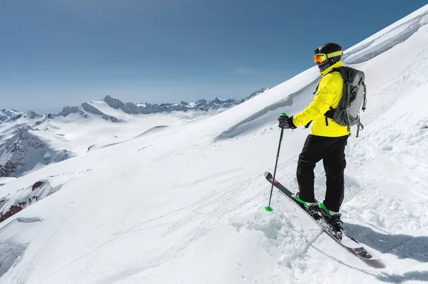Retrato de um esquiador freerider profissional em pé em uma encosta nevada contra o fundo de montanhas cobertas de neve. O conceito de esportes de inverno — Fotografia de Stock