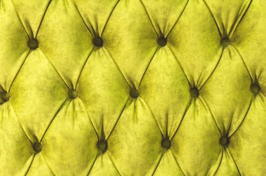 Kadife koltuk yakın çekim yüzey. Eğitim donanımları-kadife paspaslar düğmeleri ile sıkılır. Sarı chesterfield stil kapitone döşeme arka planı kapat