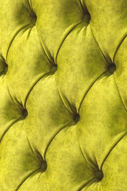 Kadife koltuk yakın çekim yüzey. Eğitim donanımları-kadife paspaslar düğmeleri ile sıkılır. Sarı chesterfield stil kapitone döşeme arka planı kapat