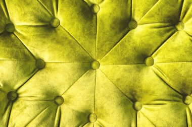 Kadife koltuk yakın çekim yüzey. Eğitim donanımları-kadife paspaslar düğmeleri ile sıkılır. Sarı chesterfield stil kapitone döşeme arka planı kapat