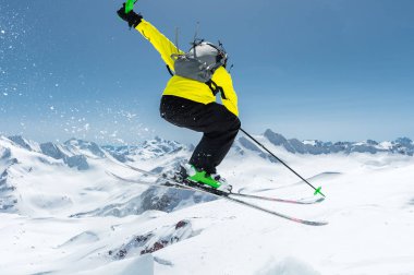 Tam bir kayakçı uçuruma ekipman atlar arka planı mavi gökyüzü ve Kafkas karla kaplı dağlar buzulun üstünden spor. Arkadan görüntüleyin. Elbrus bölge