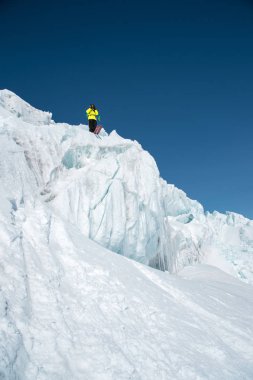Tam kıyafeti freerider kayakçı Kuzey Kafkasya'da bir buzulun üzerinde duruyor. Kayakçı buzul atlama önce hazırlama