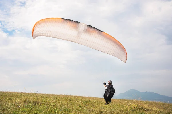 El parapente abre su paracaídas antes de despegar de la montaña en el Cáucaso Norte. Llenar el ala del paracaídas con aire antes del despegue — Foto de Stock