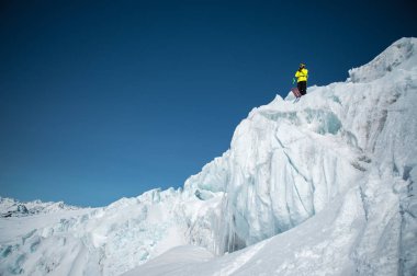 Tam kıyafeti freerider kayakçı Kuzey Kafkasya'da bir buzulun üzerinde duruyor. Kayakçı buzul atlama önce hazırlama