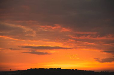 Akşam gökyüzü günbatımı kırmızı bulutlar ve küçük bir kasaba özel sektöre silueti ile sonra