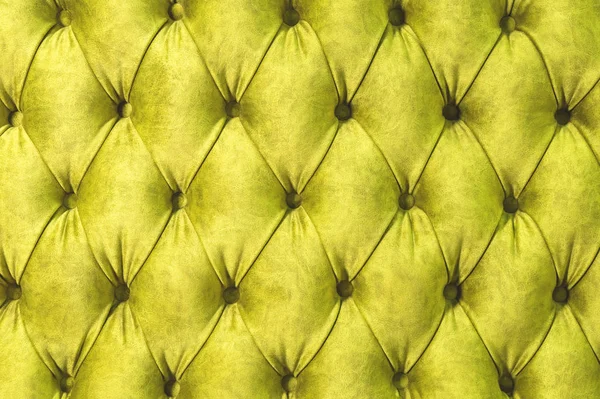 Kadife koltuk yakın çekim yüzey. Eğitim donanımları-kadife paspaslar düğmeleri ile sıkılır. Sarı chesterfield stil kapitone döşeme arka planı kapat