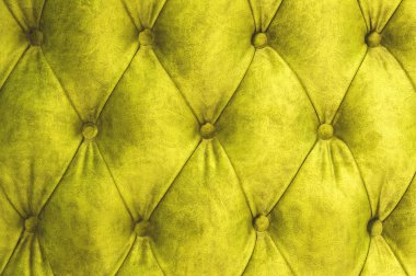 Kadife koltuk yakın çekim yüzey. Eğitim donanımları-kadife paspaslar düğmeleri ile sıkılır. Sarı chesterfield stil kapitone döşeme arka planı kapat