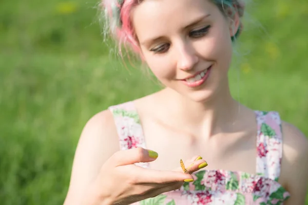 Retrato de uma bela mulher segurando uma borboleta na mão no jardim. Retrato de beleza. Unidade com a natureza. Conceito de ecologia — Fotografia de Stock