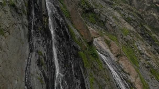 Kamerafahrten und Luftaufnahmen aus einem Wasserlauf, der an einer Felswand im Kaukasus plätschert. um den Strahl des Wasserfalls — Stockvideo