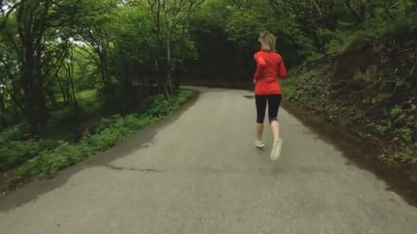 Chica corriendo. Chica rubia haciendo deportes al aire libre en el bosque de verano. Vista trasera de cámara lenta gran angular — Vídeos de Stock