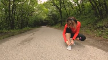 Oturan genç bir beyaz kız Kafkasya'da bir orman yolda koşu önce onun ayakkabı bağı bağlar. Geniş açı