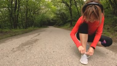 Oturan genç bir beyaz kız Kafkasya'da bir orman yolda koşu önce onun ayakkabı bağı bağlar. Geniş açı