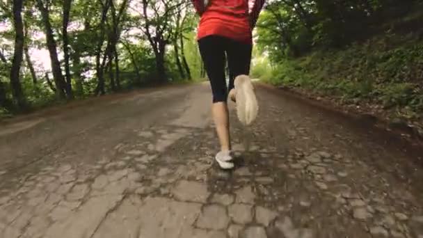 Ragazza in corsa. Ragazza bionda che fa sport all'aria aperta nella foresta estiva. Vista posteriore grandangolo rallentato. Primo piano di una ragazza gambe — Video Stock