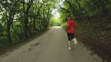 Çalışan kız. Sarışın kız yaz ormandaki açık spor yapıyor. Arka görünüm yavaş hareket geniş açı