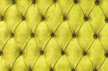 Kadife koltuk yakın çekim yüzey. Eğitim donanımları-kadife paspaslar düğmeleri ile sıkılır. Sarı chesterfield stil kapitone döşeme arka planı kapat