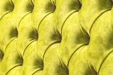 Kadife koltuk yakın çekim yüzey. Eğitim donanımları-kadife paspaslar düğmeleri ile sıkılır. Sarı chesterfield stil kapitone döşeme arka planı kapat