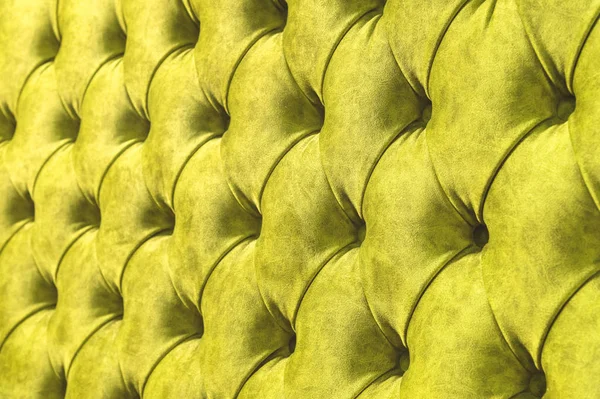 Kadife koltuk yakın çekim yüzey. Eğitim donanımları-kadife paspaslar düğmeleri ile sıkılır. Sarı chesterfield stil kapitone döşeme arka planı kapat
