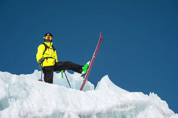 Un esquiador freerider en traje completo se encuentra en un glaciar en el Cáucaso Norte. Esquiador preparándose antes de saltar desde el glaciar —  Fotos de Stock