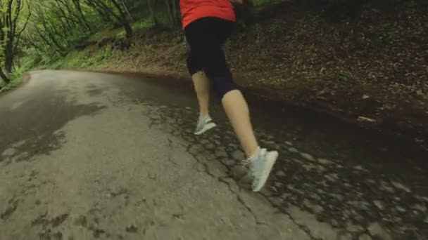 Running girl. Menina loira fazendo esportes ao ar livre na floresta de verão. Visão traseira ângulo largo de câmera lenta. Close-up de um meninas pernas — Vídeo de Stock