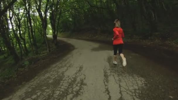 Chica corriendo. Chica rubia haciendo deportes al aire libre en el bosque de verano. Vista trasera de cámara lenta gran angular — Vídeos de Stock