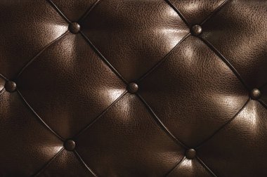 Düğmeleri ile bir rhombic bölünmüş deri yüzeyine yatağın arkasında. Rhombic desen toplu cilt Brown. Taşan kasa yüzeyi