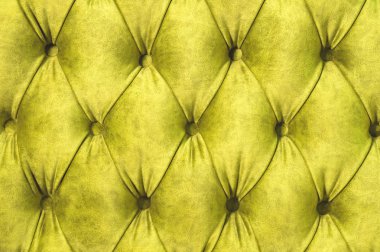 Kadife koltuk yakın çekim yüzey. Eğitim donanımları-kadife paspaslar düğmeleri ile sıkılır. Sarı chesterfield stil kapitone döşeme arka planı kapat