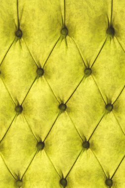 Kadife koltuk yakın çekim yüzey. Eğitim donanımları-kadife paspaslar düğmeleri ile sıkılır. Sarı chesterfield stil kapitone döşeme arka planı kapat