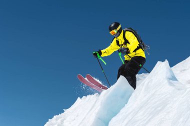 Bir kayakçı tam uçurumun içine ekipman atlar arka planı mavi gökyüzü ve Kafkas karla kaplı dağlar buzulun üstünden spor. Elbrus bölge. Rusya