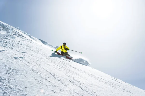 La longitud total del esquí sobre nieve fresca en polvo. Esquiador profesional fuera de la pista en un día soleado — Foto de Stock