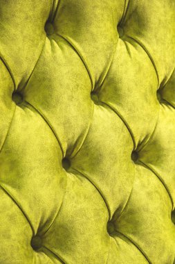 Kadife koltuk yakın çekim yüzey. Eğitim donanımları-kadife paspaslar düğmeleri ile sıkılır. Sarı chesterfield stil kapitone döşeme arka planı kapat