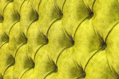 Kadife koltuk yakın çekim yüzey. Eğitim donanımları-kadife paspaslar düğmeleri ile sıkılır. Sarı chesterfield stil kapitone döşeme arka planı kapat