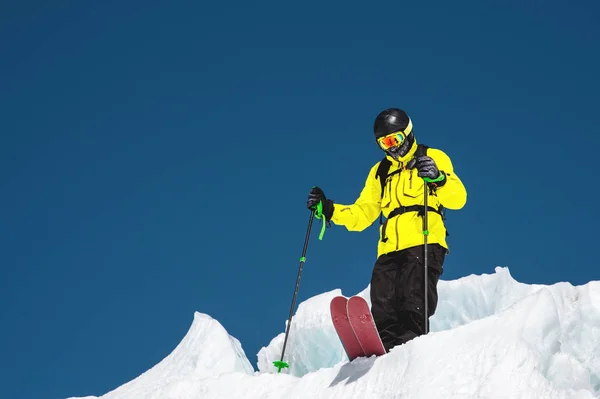 Un esquiador freerider en traje completo se encuentra en un glaciar en el Cáucaso Norte. Esquiador preparándose antes de saltar desde el glaciar —  Fotos de Stock