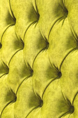 Kadife koltuk yakın çekim yüzey. Eğitim donanımları-kadife paspaslar düğmeleri ile sıkılır. Sarı chesterfield stil kapitone döşeme arka planı kapat