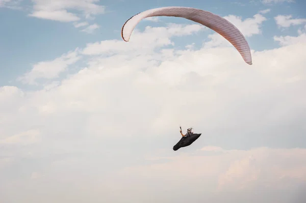 Alone paraglider flying in the blue sky against the background of clouds. Paragliding in the sky on a sunny day — Stock Photo, Image