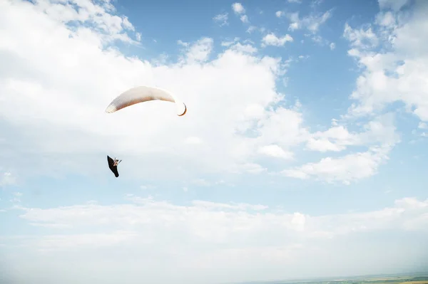 Alone paraglider flying in the blue sky against the background of clouds. Paragliding in the sky on a sunny day — Stock Photo, Image