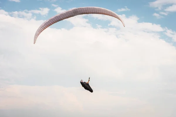 Alone paraglider flying in the blue sky against the background of clouds. Paragliding in the sky on a sunny day — Stock Photo, Image