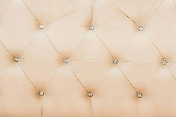 Fondo in morbido tessuto beige con bottoni simmetrici agli angoli dei diamanti. Elementi d'arredo morbidi e costosi. sfondo di lusso — Foto Stock