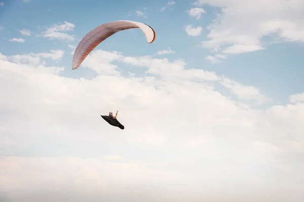 Yalnız yamaçparaşütü bulutlar arka planı mavi gökyüzünde uçan. Güneşli bir havada yamaç paraşütü — Stok fotoğraf