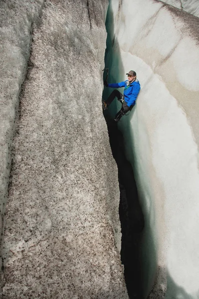 Egy ingyenes mászó biztosító jég Kéttengelyes nélkül emelkedik ki egy repedés a a gleccser. Ingyenes hegymászó kötelek nélkül — Stock Fotó