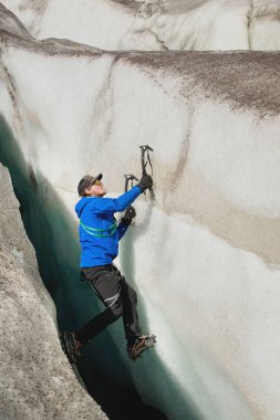 İki Buz baltaları ile sigorta olmadan ücretsiz bir dağcı buzulun bir boşlukta üzerinden yükselir. Ücretsiz halat tırmanma
