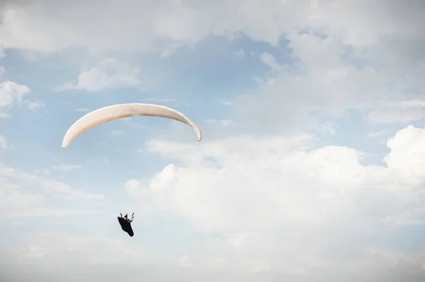 Alone paraglider flying in the blue sky against the background of clouds. Paragliding in the sky on a sunny day — Stock Photo, Image